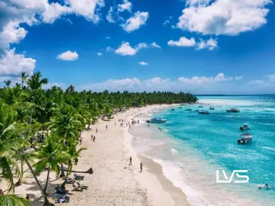 a beach with palm trees and people on the beach at Zen Oasis Villa at Casa de Campo in La Romana