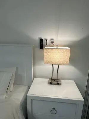 a lamp on a night stand next to a bed at Luxury Apartment Hot Water,AC,WiFi,PS3 in San Felipe de Puerto Plata