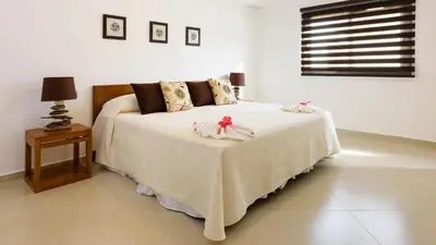 a bedroom with a large white bed with a table at Aligio Apart-hotel & Spa - Las Terrenas in Las Terrenas