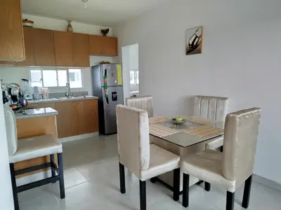 a kitchen with a table and chairs and a refrigerator at Higüey City Home in Higuey