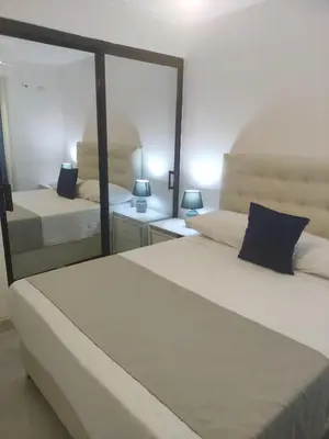a bedroom with two beds and a large mirror at santiago de los caballeros hipanoamericana in Santiago de los Caballeros