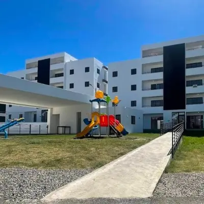 a playground in front of a building with a slide at santiago de los caballeros hipanoamericana in Santiago de los Caballeros