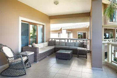 a patio with a couch and chairs on a balcony at Ocean front 2bdrm-2bath at Ocean Point 1 - Kitebeach Cabarete in Cabarete