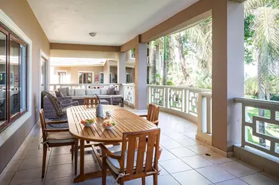 a porch with a wooden table and chairs at Ocean front 2bdrm-2bath at Ocean Point 1 - Kitebeach Cabarete in Cabarete