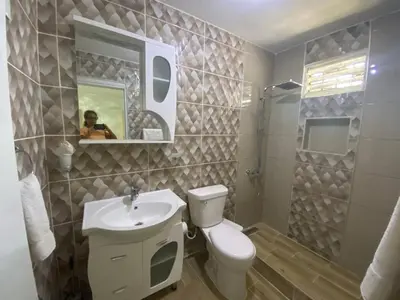 a bathroom with a toilet and a sink and a mirror at 6B Santiago Harmonic Apt Especially For You in Santiago de los Caballeros