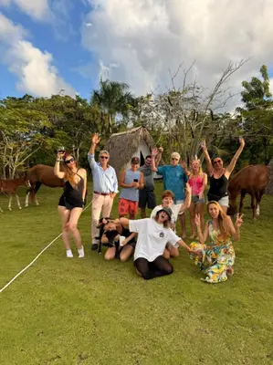 a group of people are posing for a picture at Eco Lodges & Camping, Chalets Tropicales, Macao Beach, Bávaro, Punta Cana in Punta Cana