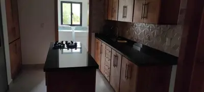 a kitchen with a black counter top and wooden cabinets at Villa Dario in Nagua