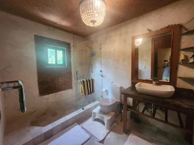 a bathroom with a sink and a toilet and a mirror at Villa Tesoros del Mar - Luxury Beachfront Villa with Natural Pool, Jacuzzi, Mountain Views, Yoga, BBQ, Wi-Fi, Pet & Family Friendly, Barahona Adventures in El Arroyo