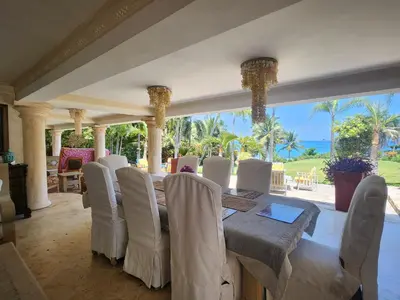 a dining room with a table and white chairs at Villa Tesoros del Mar - Luxury Beachfront Villa with Natural Pool, Jacuzzi, Mountain Views, Yoga, BBQ, Wi-Fi, Pet & Family Friendly, Barahona Adventures in El Arroyo