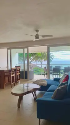 a living room with a blue couch and a table at B3 beautiful ocean view penthouse - Ocean Front in Cabarete
