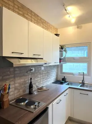 a kitchen with white cabinets and a wooden counter top at Cozy Apartment in Las Galeras in Las Galeras