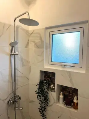 a bathroom with a shower and a television on the wall at Cozy Apartment in Las Galeras in Las Galeras