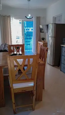 a kitchen with a wooden table and a dining table and chairs at apart Jacaranda Bayahibe in Bayahibe