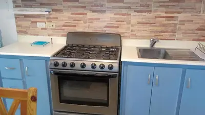 a kitchen with a stove top oven next to a sink at apart Jacaranda Bayahibe in Bayahibe