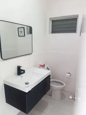a white bathroom with a sink and a toilet at Ocean Bliss in Sosúa