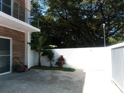 a courtyard of a house with a fence and a tree at Ocean Bliss in Sosúa