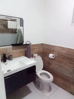 a bathroom with a white toilet and a sink at Ocean Bliss in Sosúa