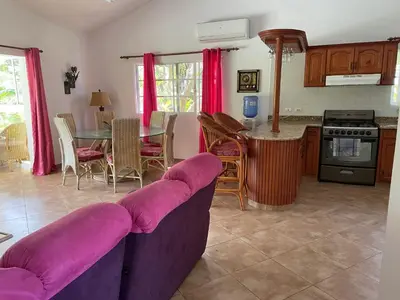 a living room with a purple couch and a table at Luxurious Villa in Sosúa + Pool in Sosúa
