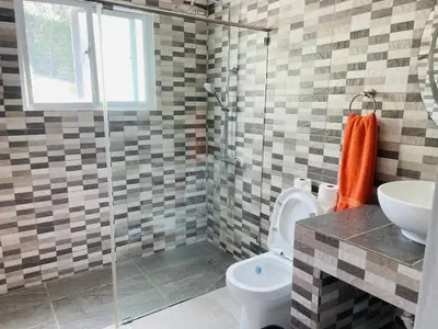 a bathroom with a shower and a toilet and a sink at Luxurious Villa in Sosúa + Pool in Sosúa