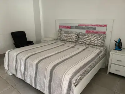 a bedroom with a bed and a black chair at Luxurious Villa in Sosúa + Pool in Sosúa