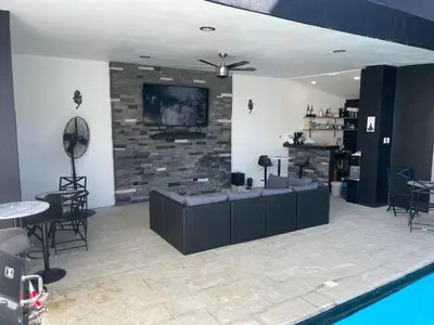 a living room with a tv on a brick wall at Level suites VIP in Sosúa