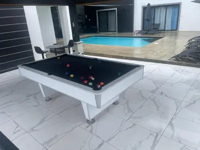 a pool table sitting on a patio next to a swimming pool at Level suites VIP in Sosúa