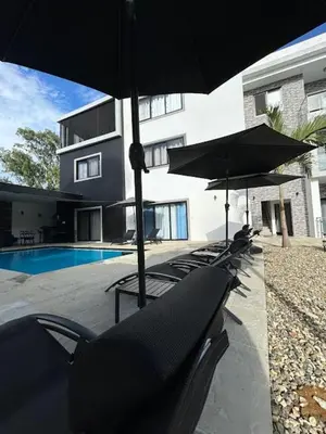 a row of chairs with umbrellas in front of a building at Level suites VIP in Sosúa