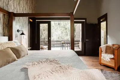 a bedroom with a large bed and a chair at Villa de Estilo Japones in Jarabacoa