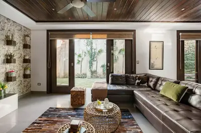 a living room with a leather couch and a table at Villa de Estilo Japones in Jarabacoa