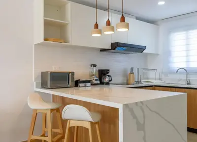 a kitchen with a counter and two stools at Beautiful apartment with direct access to the pool in Punta Cana