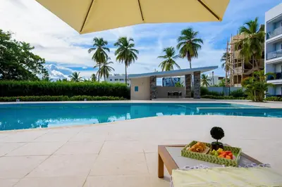 a bowl of fruit sitting on a table next to a swimming pool at Beautiful apartment with direct access to the pool in Punta Cana
