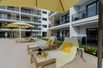 a hotel patio with chairs and an umbrella at Beautiful apartment with direct access to the pool in Punta Cana