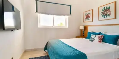 a bedroom with a bed with blue and white at Cana Rock Condos in Punta Cana