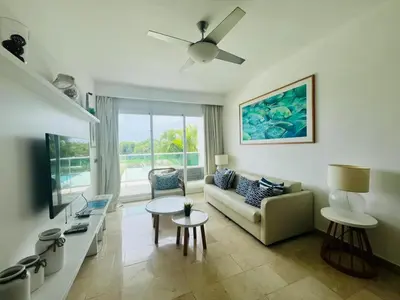 a living room with a couch and a tv at Cana Rock Condos in Punta Cana