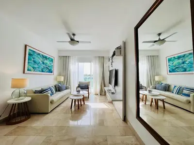 a living room with a couch and a mirror at Cana Rock Condos in Punta Cana
