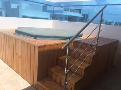 a bed on a wooden platform with a stair case at Apartamento completo con jacuzzi y gazebo in Santo Domingo