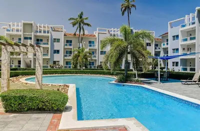 a pool in front of a large apartment building at Tropical apartment 2 Bedroon in Los Corales in Punta Cana