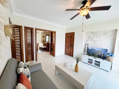 a living room with a couch and a tv at Tropical apartment 2 Bedroon in Los Corales in Punta Cana