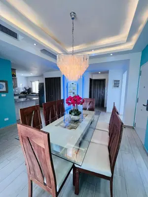 a glass dining room table with chairs and a chandelier at Luxury Gateaway Penthouse in front of Hard Rock in Punta Cana