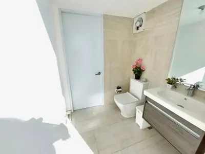 a white bathroom with a toilet and a sink at Luxury Gateaway Penthouse in front of Hard Rock in Punta Cana