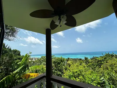 a view of the ocean from a porch with an umbrella at Casa Vista Mar, Los Patos, Barahona - 4x4 or All Terrain Vehicle to Access Property in Los Patos