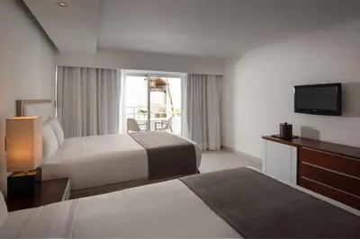 a hotel room with two beds and a television at Select Sosua Adults Only, Trademark by Wyndham All Inclusive in Sosúa