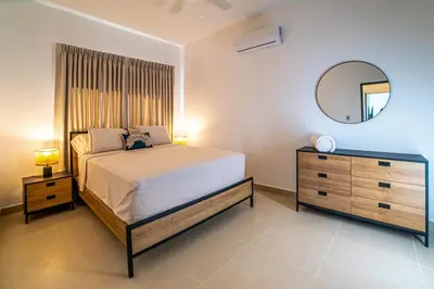 a bedroom with a bed and a dresser and a mirror at Atlantic Paradise Cabrera in Arroyo Azul