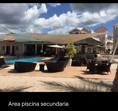 a resort with a swimming pool and tables and chairs at Cadaqués, Bayahibe, República Dominicana in Bayahibe