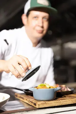 a man holding a cell phone next to a bowl of food at El Colibri Hotel in Sosúa