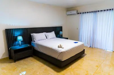 a bedroom with a bed with a teddy bear on it at El Colibri Hotel in Sosúa