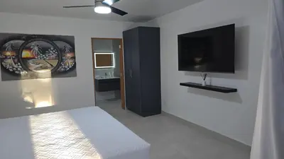 a bedroom with a bed and a flat screen tv at El Colibri Hotel in Sosúa