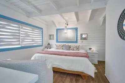 a white bedroom with a bed and a window at New-CasitaDeLasFlores-View-Wifi-Jacuzzi-Jarabacoa in Jarabacoa