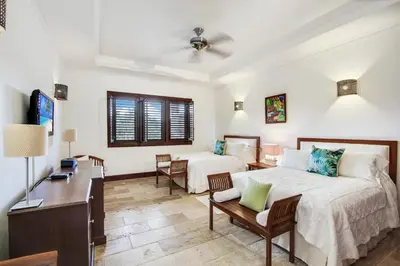 a bedroom with a bed and a desk and a couch at Gorgeous villa at Casa de Campo - with large pool, cook, maid and 2 golf carts in La Romana