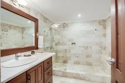 a bathroom with a sink and a tub and a mirror at Gorgeous villa at Casa de Campo - with large pool, cook, maid and 2 golf carts in La Romana